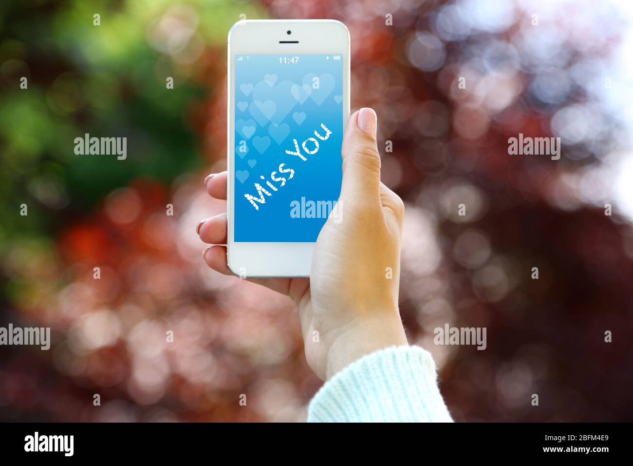 Junge Frau mit Smartphone mit romantischen Bildschirmschoner Stockfoto
