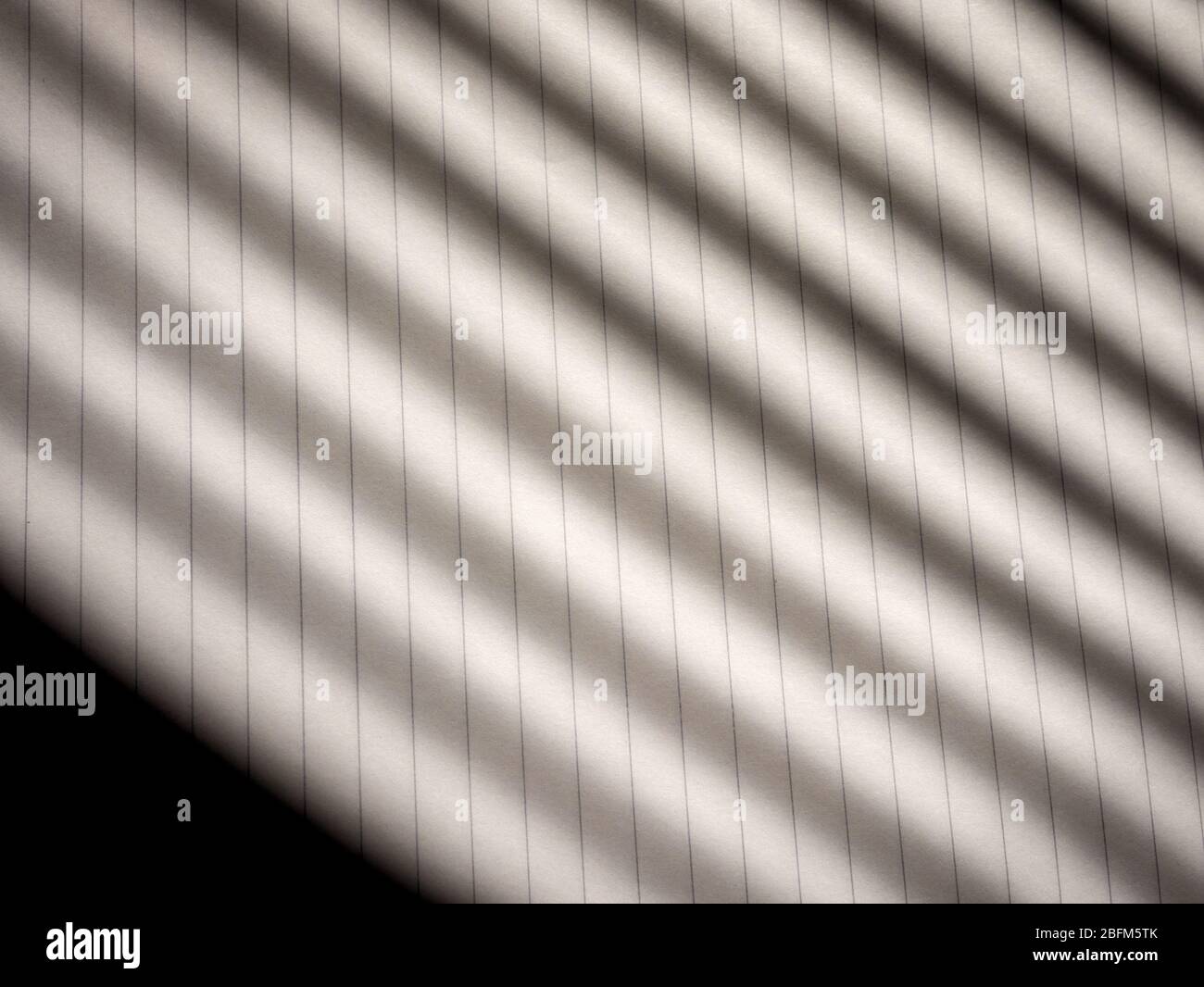 Schatten, die von Jalousien auf Papier geworfen werden Stockfoto