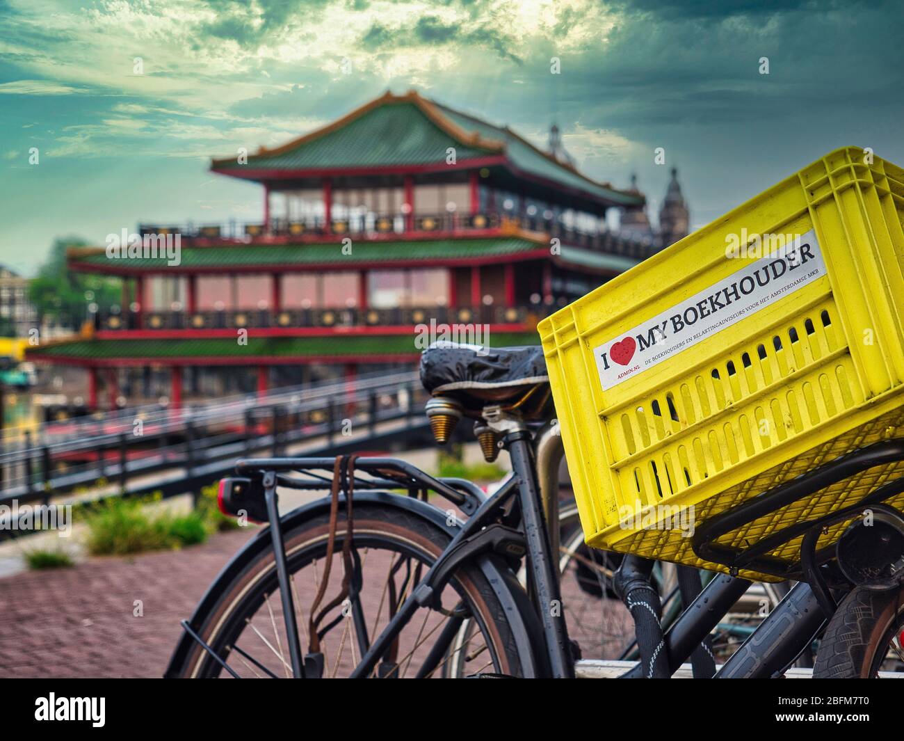 Radfahren in Amsterdam mit chinesischem Restaurant im Hintergrund Stockfoto