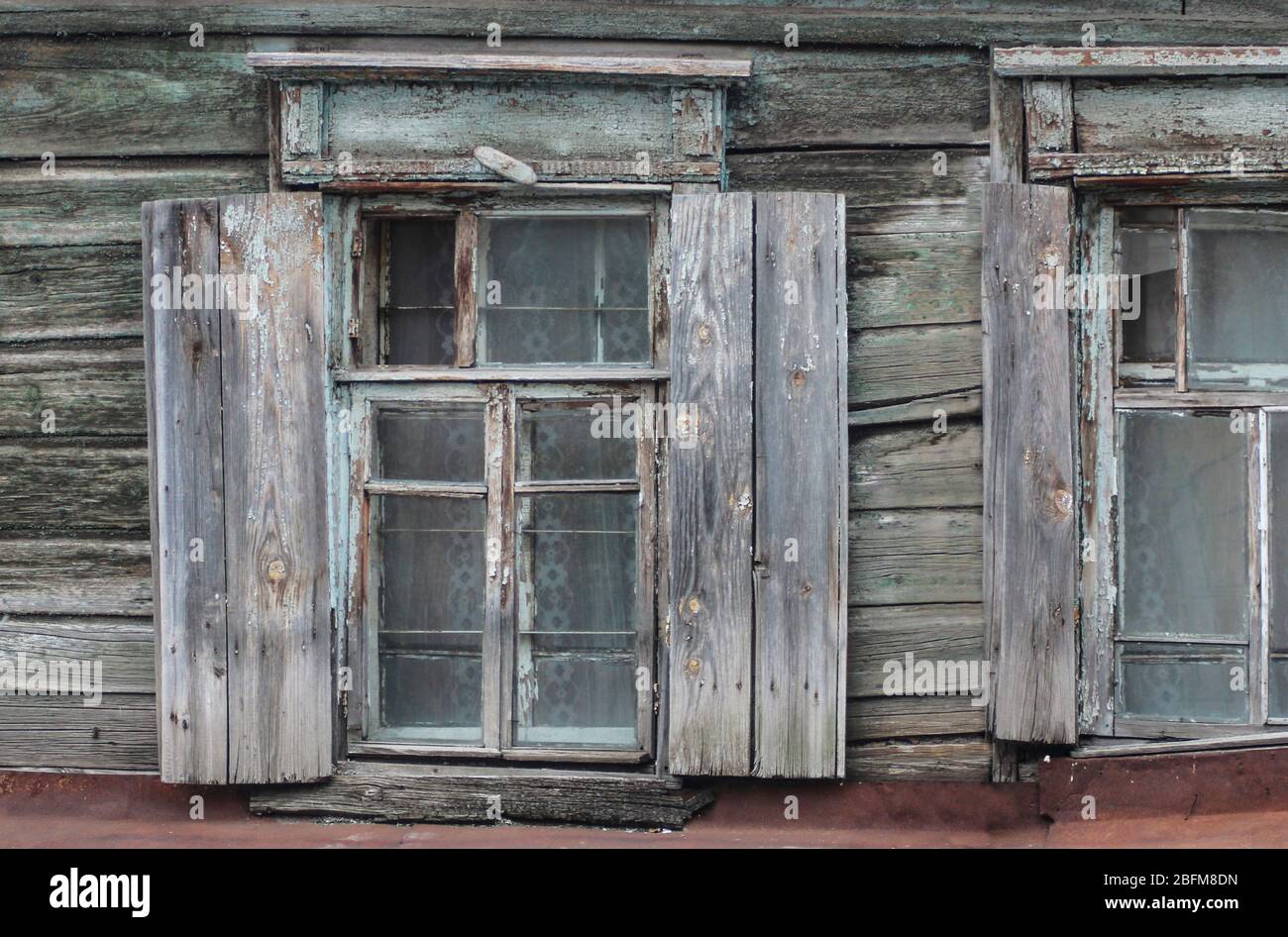 Fenster eines alten Holzhauses mit Fensterläden Stockfoto