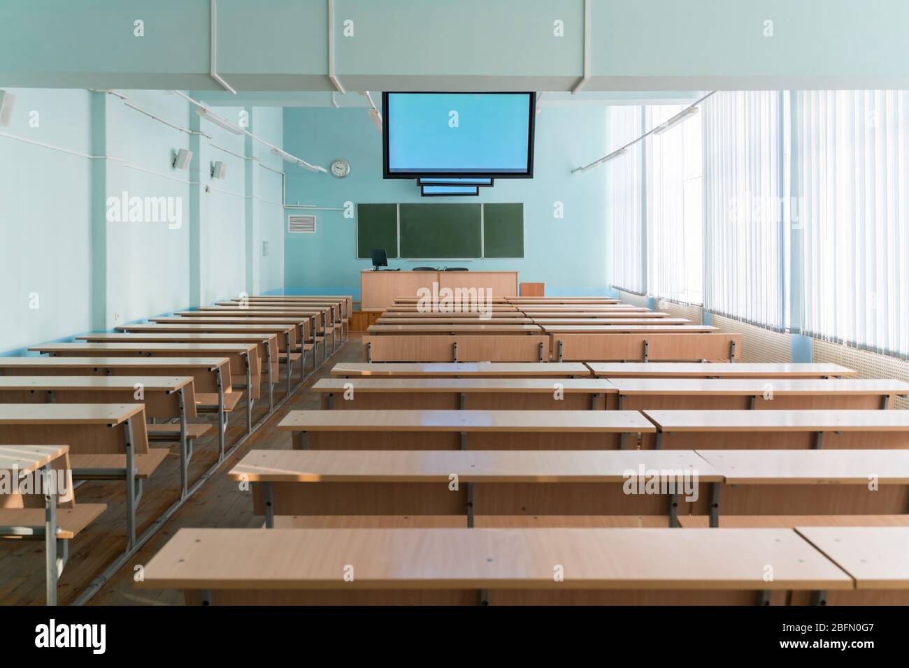 Leeres Klassenzimmer mit Monitoren an der Decke für Vorlesungen an der Universität Stockfoto