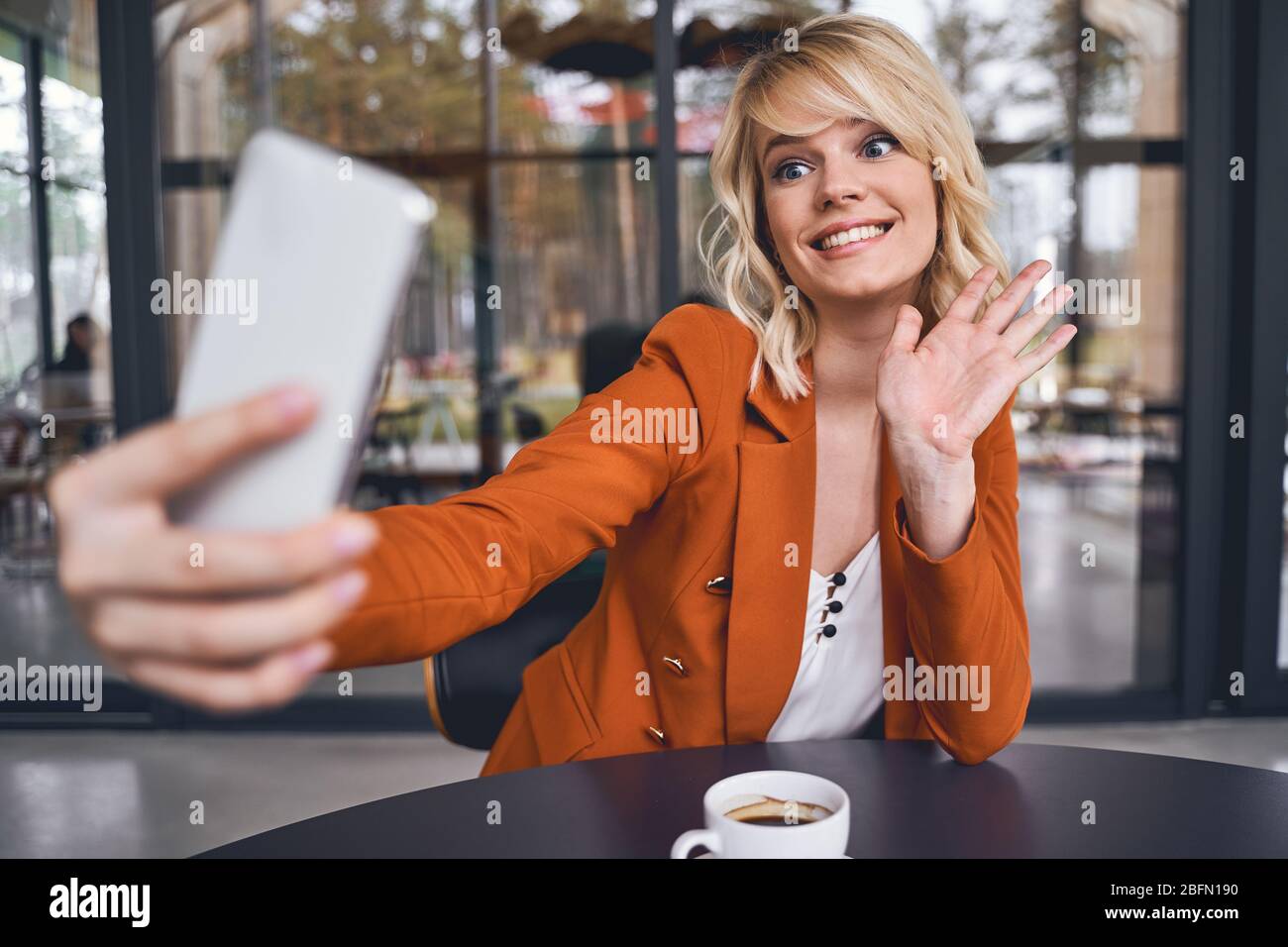 Frau mit Smartphone, die Spaß an der Arbeit hat Stockfoto