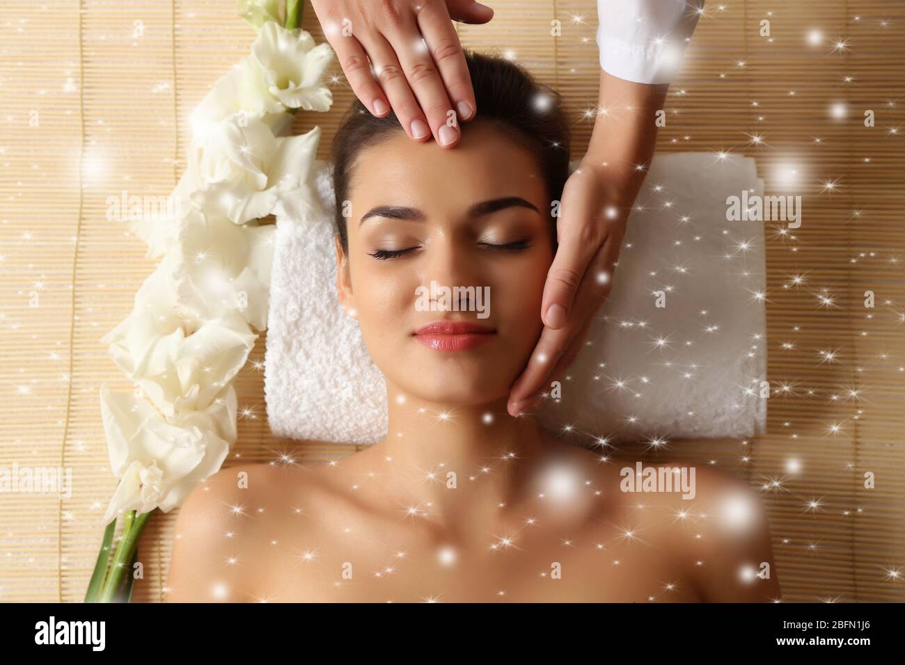 Junge Frau im Beauty-Spa-Salon genießen Kopfmassage mit Schnee-Effekt Stockfoto