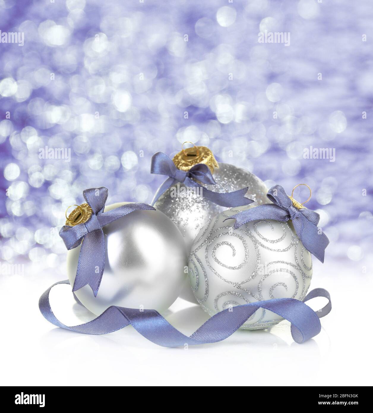Weihnachtskugeln auf glänzendem lila Hintergrund Stockfoto