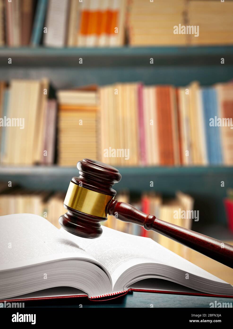 Richter gavel und Buch auf dem Tisch auf Bücherregalen Hintergrund Stockfoto