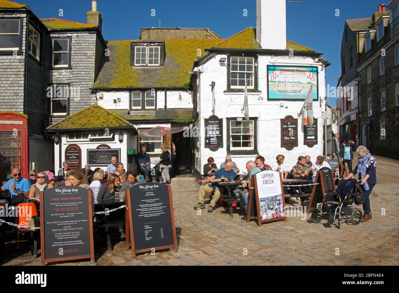 Leute, die einen Drink genießen Sloop Inn St Ives Cornwall England Stockfoto