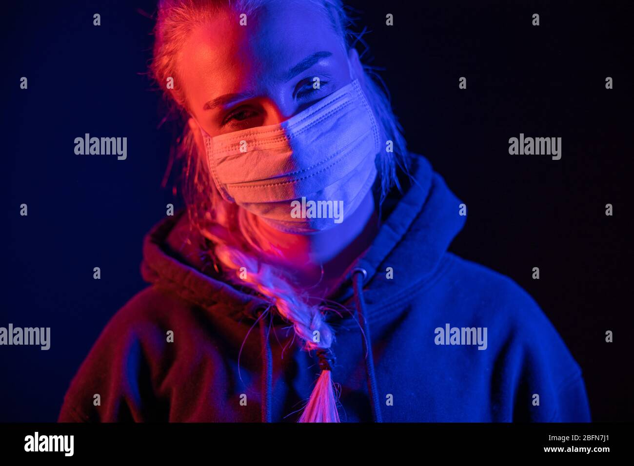 Erschöpft oder krank Frau in schützende Gesichtsmaske mit bunten Lichtern Stockfoto
