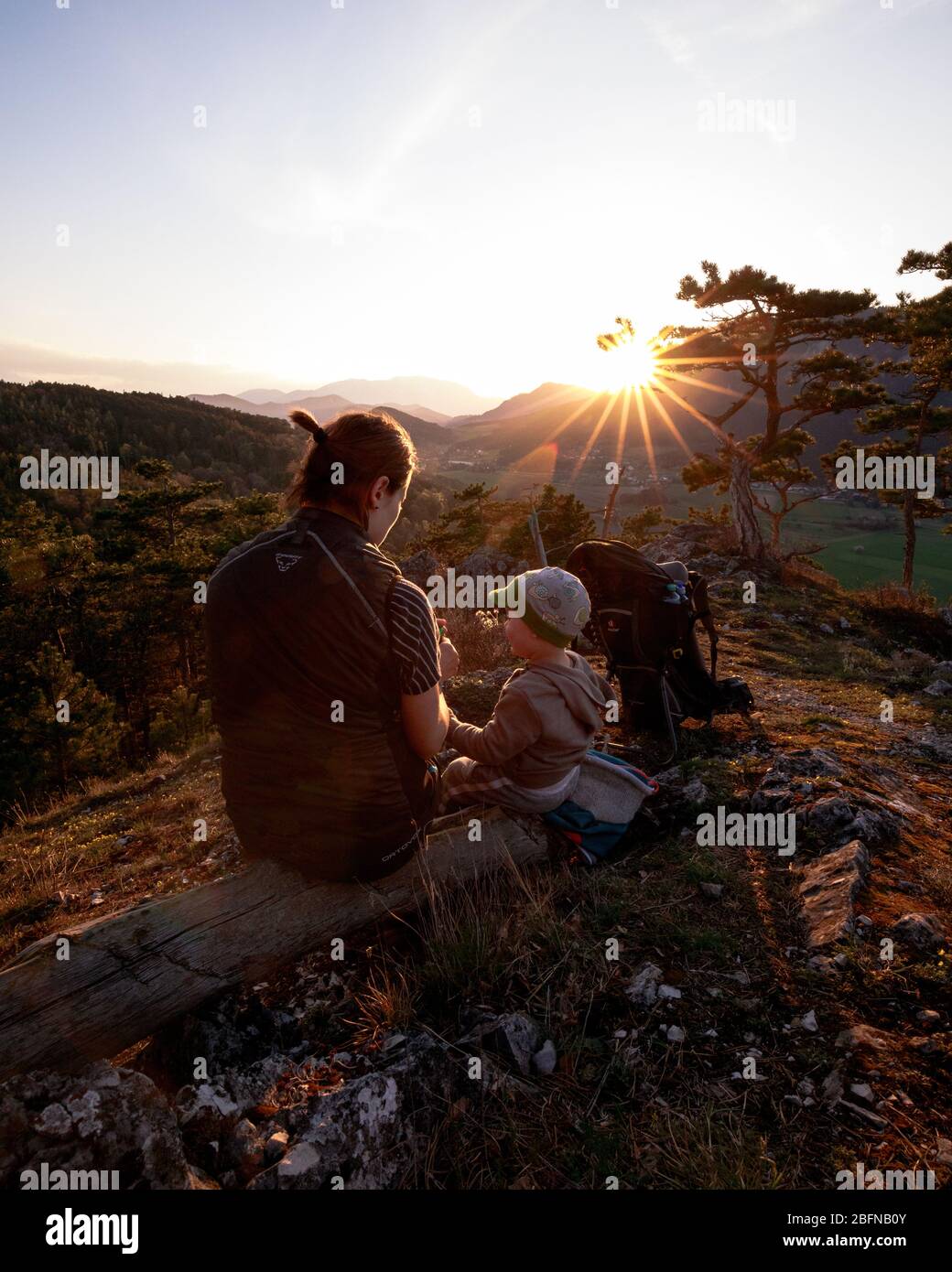 Frau mit Kind gemeinsam im Freien im Sommer auf einem Berggipfel bei Sonnenuntergang Stockfoto