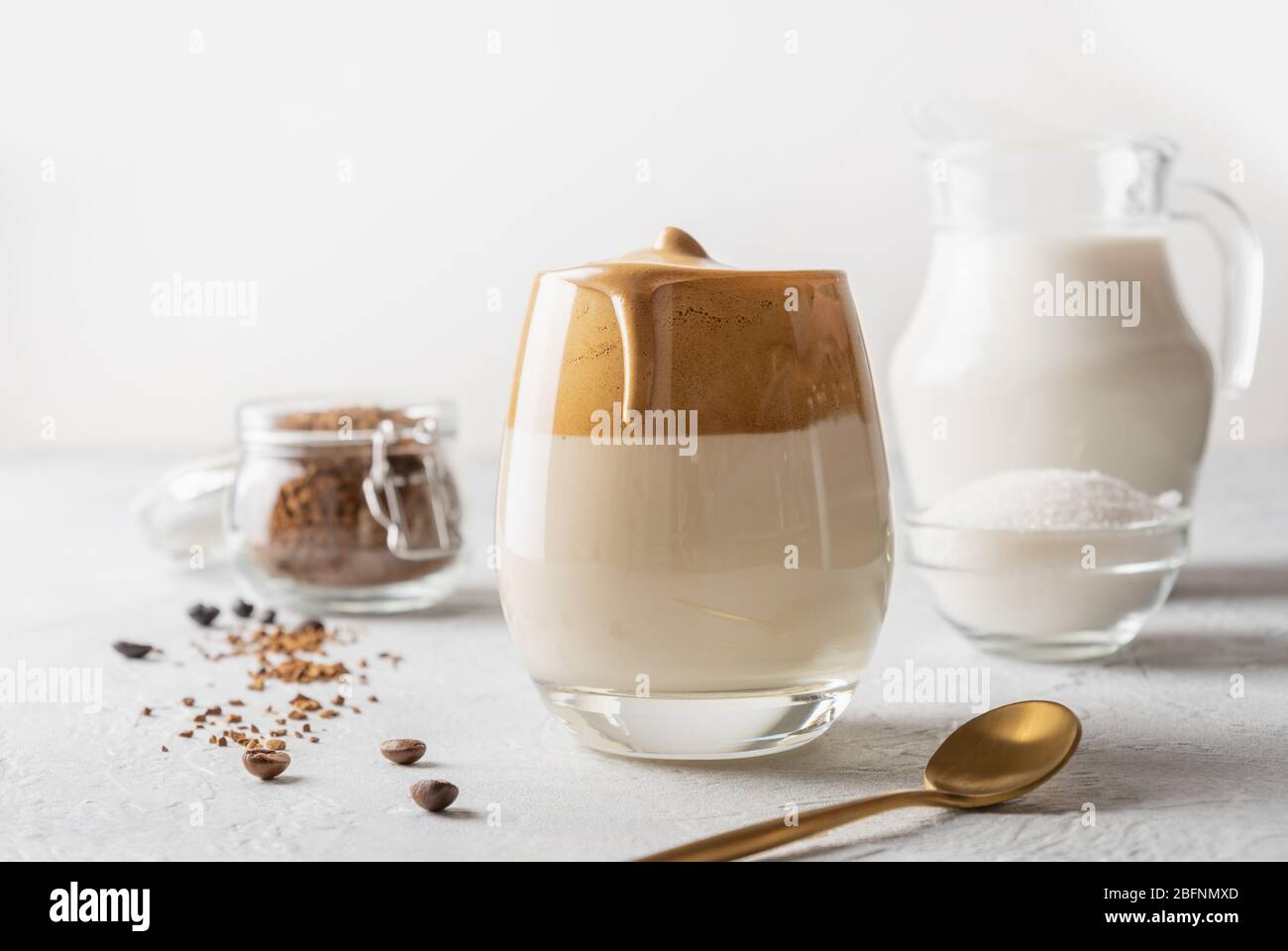 Hausgemachter Dalgona Kaffee im Glas mit Zutaten. Rezept populäre koreanische Getränk Latte mit Schaum von Instant-Kaffee. Stockfoto