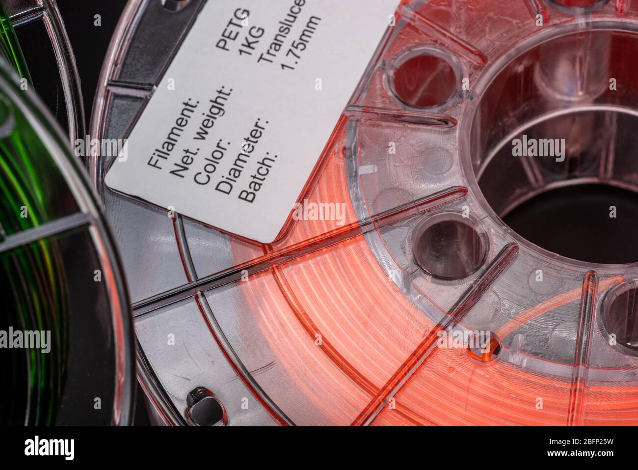 Rollen von 1,75 mm 3d-Druck-Filament, transluzent grün und transluzent orange, dunkler Hintergrund Stockfoto