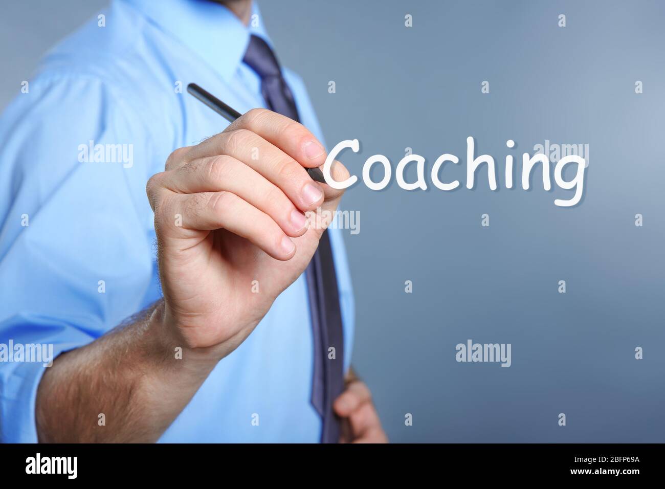 Konzept des persönlichen Coachings. Männliche Hand mit Bleistift auf blauem Hintergrund Stockfoto