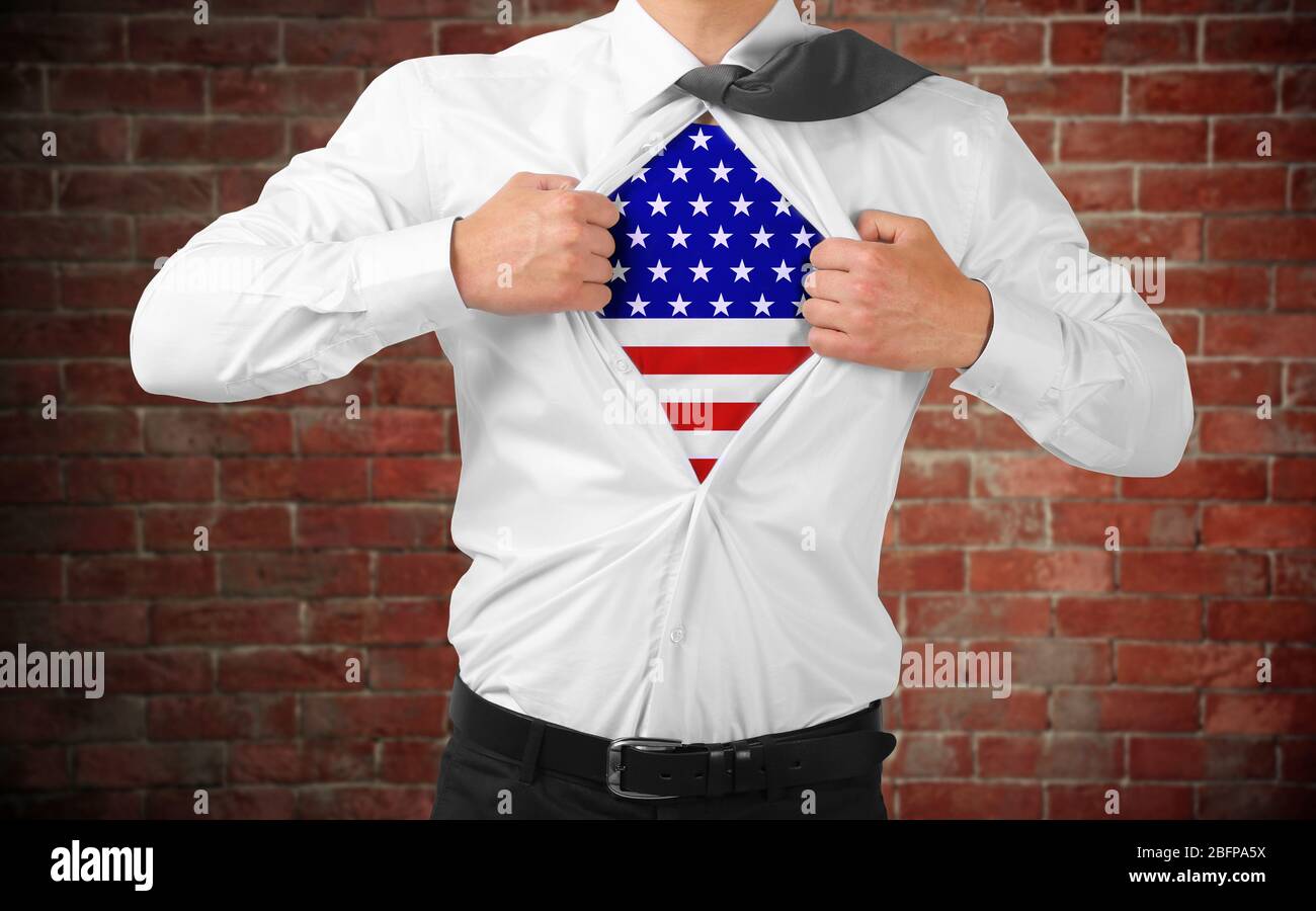 Geschäftsmann zeigt USA Flagge unter Anzug auf Backstein Wand Hintergrund. Stockfoto