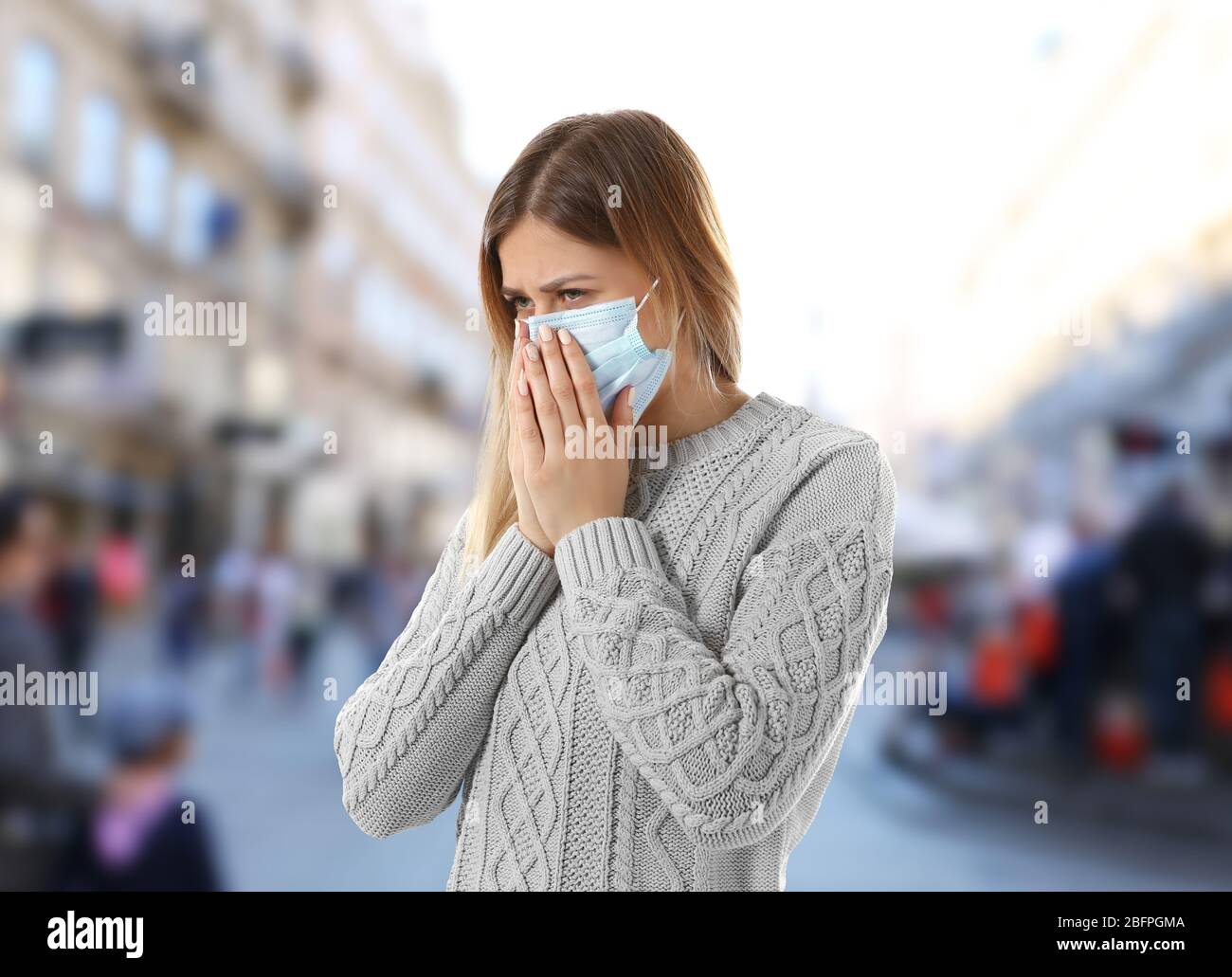 Konzept der Gesundheitsfürsorge. Junge Frau in Gesichtsmaske auf der Stadtstraße Stockfoto