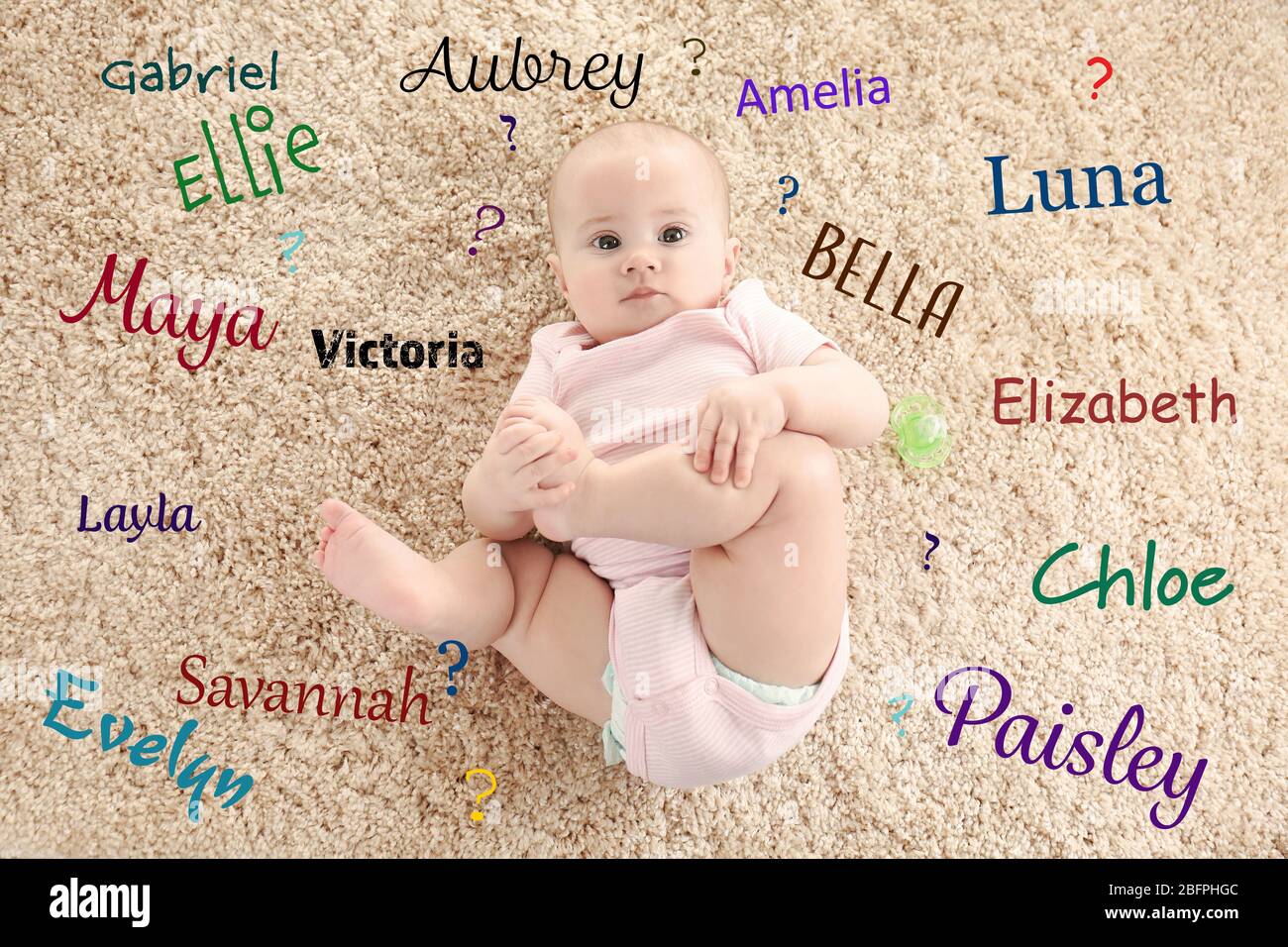 Konzept für Babynamen. Nettes kleines Mädchen auf dem Teppich liegend Stockfoto