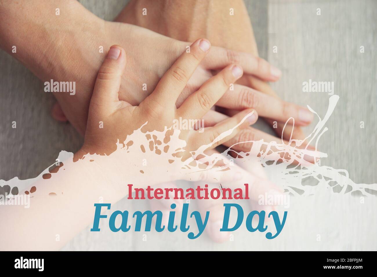 Text INTERNATIONALER FAMILIENTAG und Hände von Eltern mit Kind auf Hintergrund. Urlaubskonzept Stockfoto