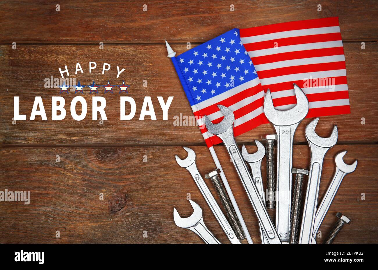 Text HAPPY LABOR DAY mit amerikanischer Flagge und Werkzeuge auf Holzhintergrund Stockfoto