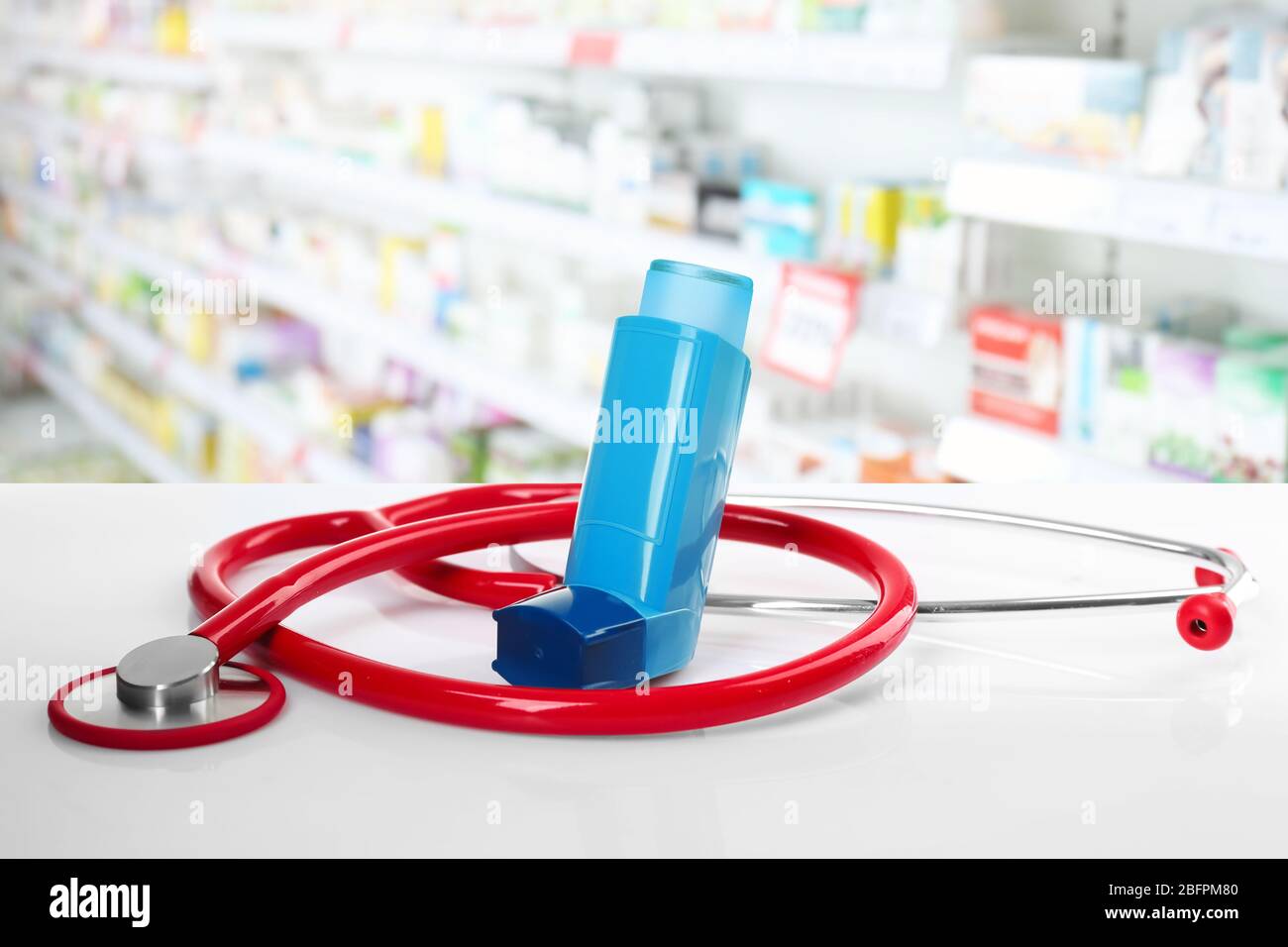 Konzept der Gesundheitsversorgung und Asthma. Inhalator mit Stethoskop am  Schalter in der Apotheke Stockfotografie - Alamy