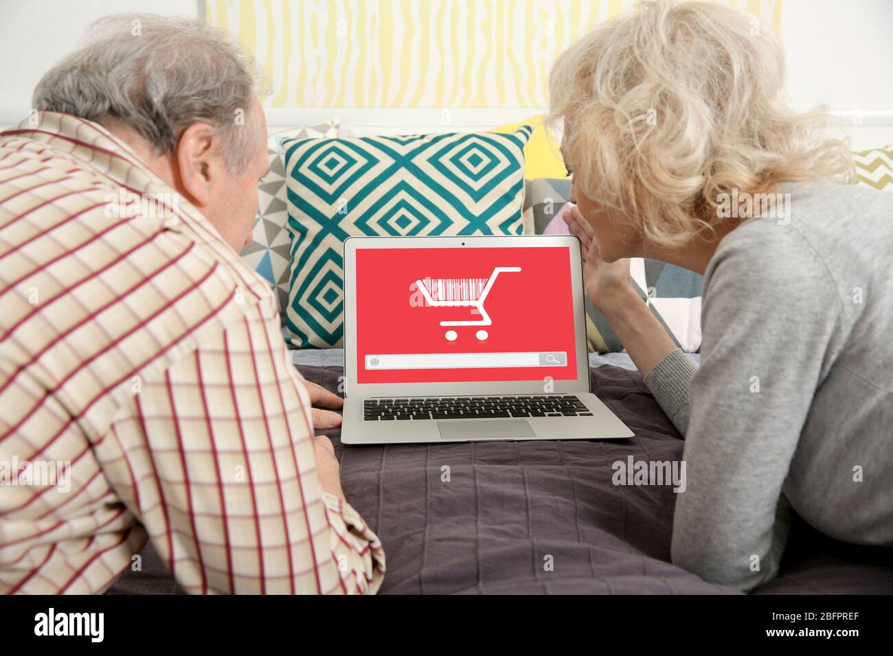 Internet-Shopping-Konzept. Seniorenpaar, die zuhause einen Laptop benutzen Stockfoto