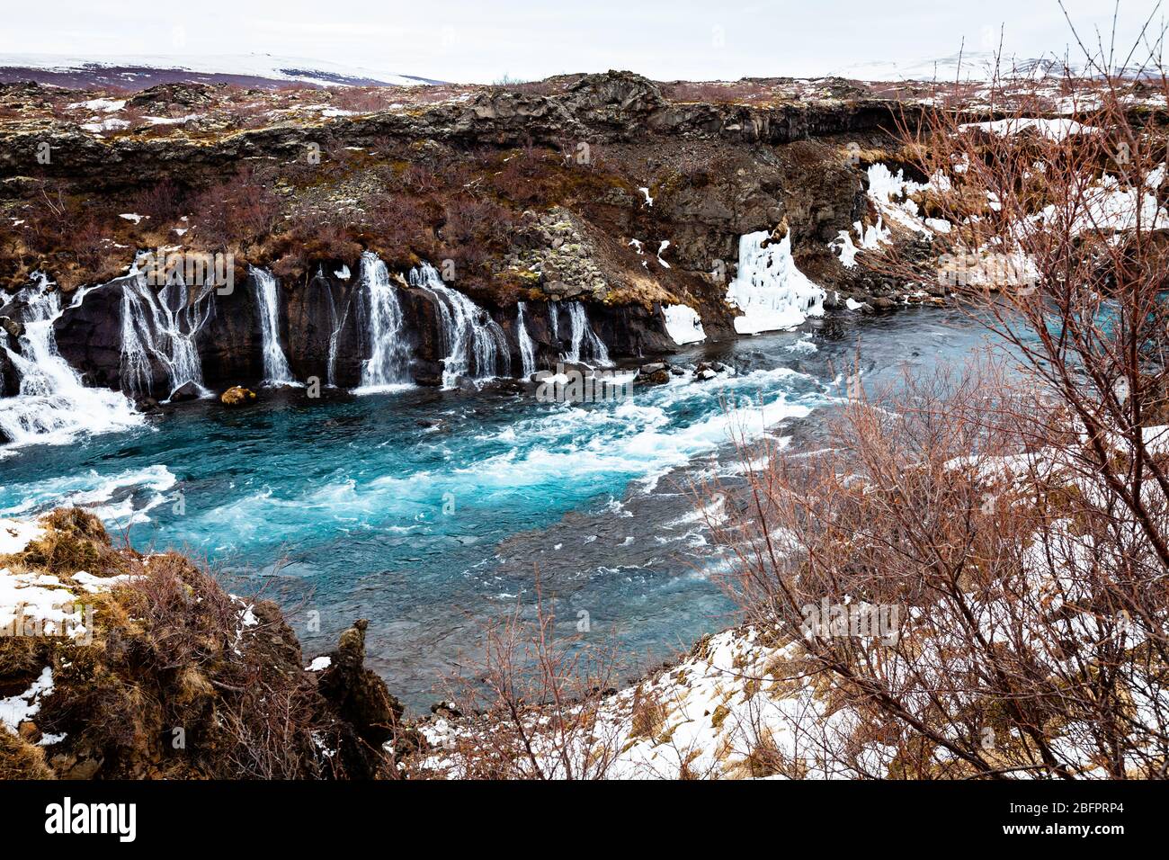 Hraunfossar Wasserfälle, die im Winter in den von Gletschern gespeisten Hvita Fluss in Island stürzen Stockfoto