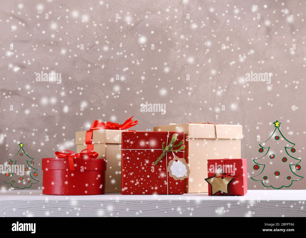 Geschenke und Zeichnungen von Weihnachtsbäumen auf farbigem Hintergrund. Konzept des Boxtages. Schnee-Effekt Stockfoto