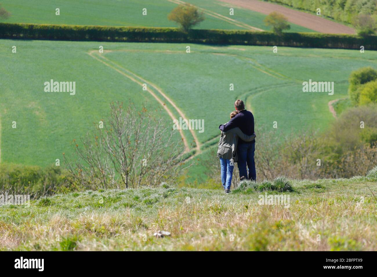 Ein liebevolles Paar, das sich eine Kuschel teilt und dabei die Aussicht von der Spitze des Billy Wood in Kippax genießt. Stockfoto
