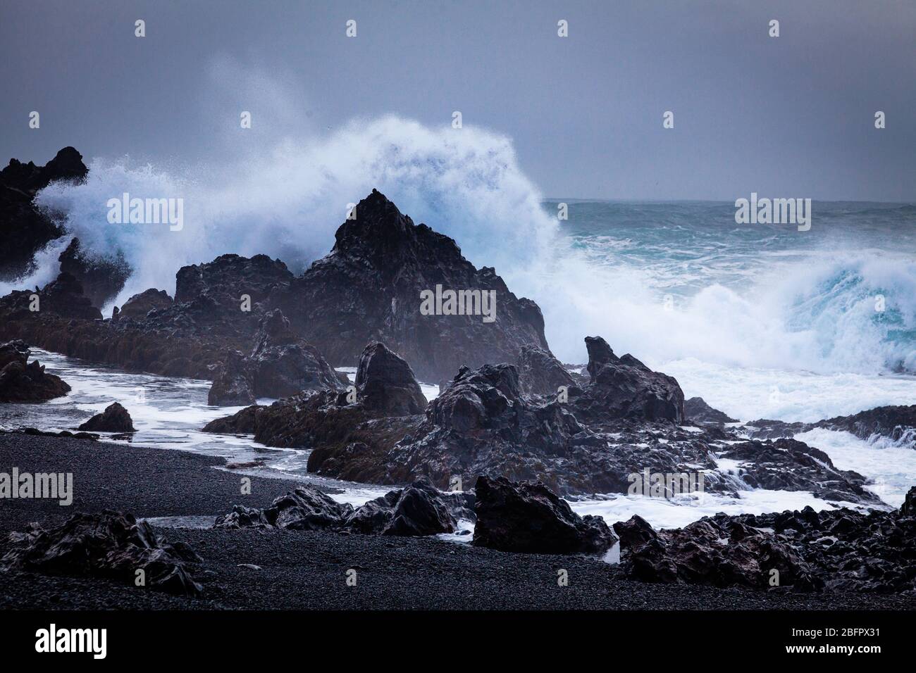 Große Welle auf schwarzem Felsen am Djupalonssandur Dritvik Strand im Snaefellsnes Nationalpark, Island Stockfoto