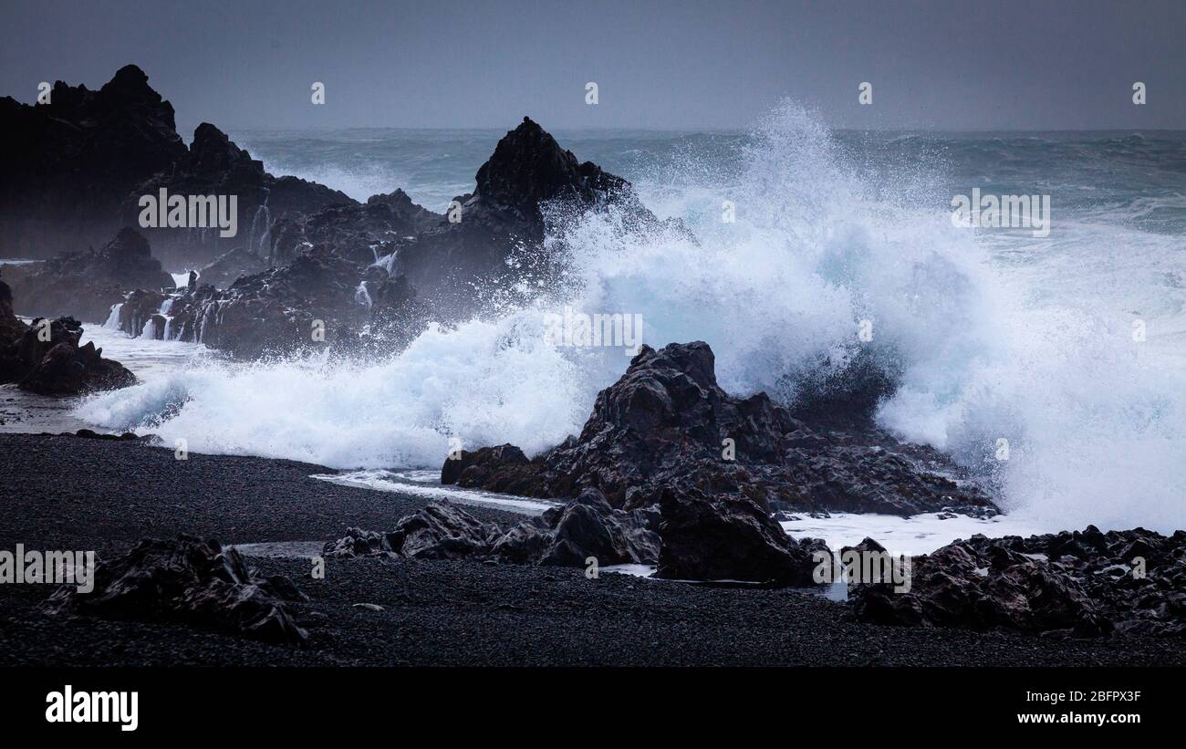 Große Welle auf schwarzem Felsen am Djupalonssandur Dritvik Strand im Snaefellsnes Nationalpark, Island Stockfoto