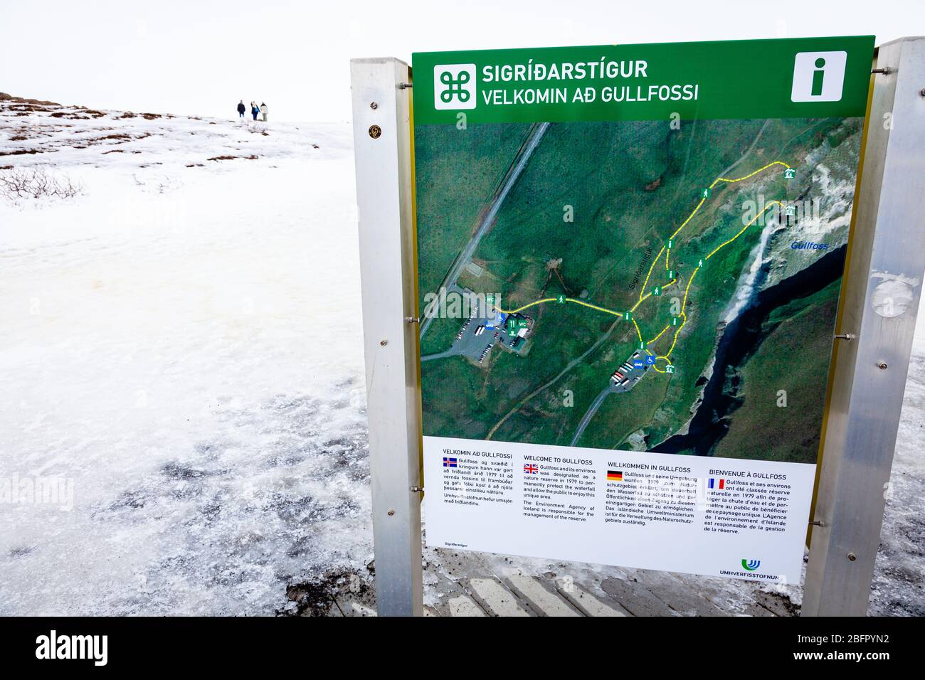 Im Winter lädt ein Schild die Besucher zum gefrorenen Wasserfall in Gullfoss, Golden Circle, Island im Schnee ein Stockfoto