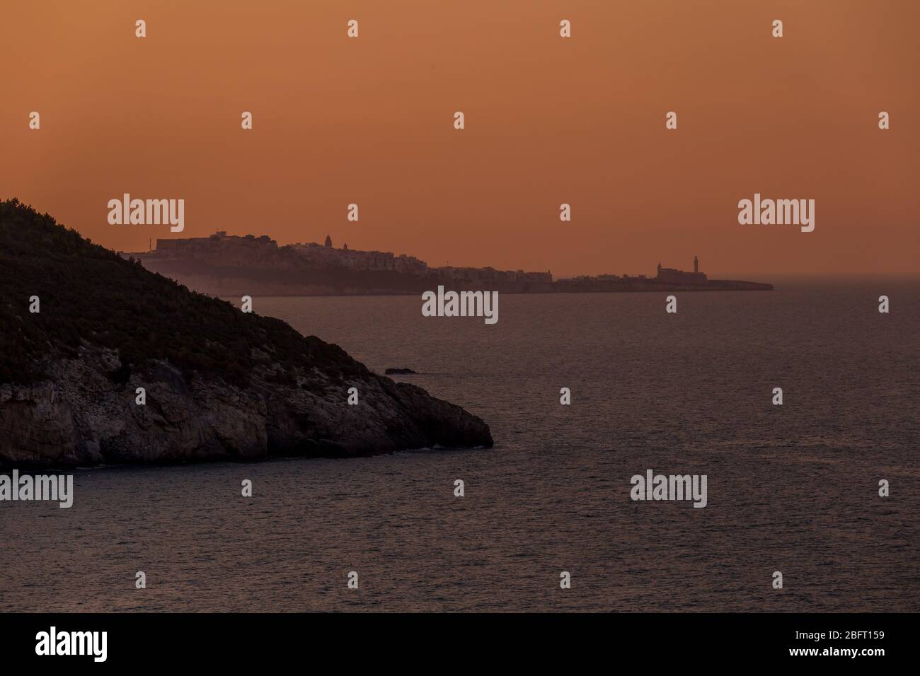 Malerische Küste der Halbinsel Gargano im Abendlicht. Im Hintergrund Vieste Stadt, Italien Stockfoto