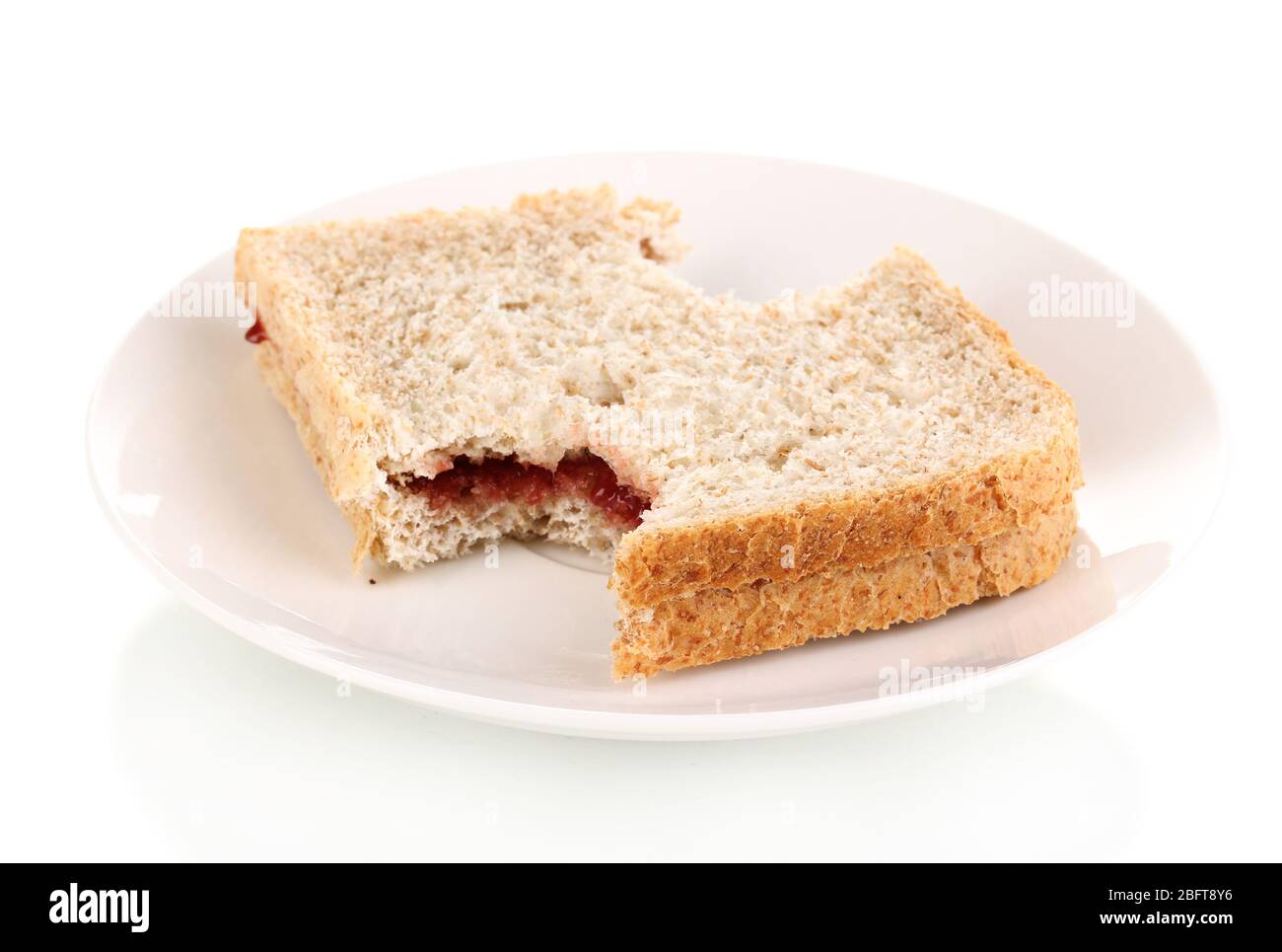 Gebissene Sandwich mit Marmelade auf Platte isoliert auf weiß Stockfoto