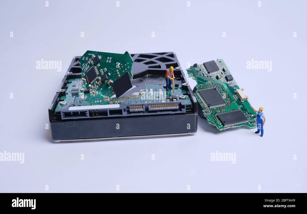 Modellfiguren funktionieren auf einer defekten Festplatte, weißem Hintergrund und Kopierplatz Stockfoto
