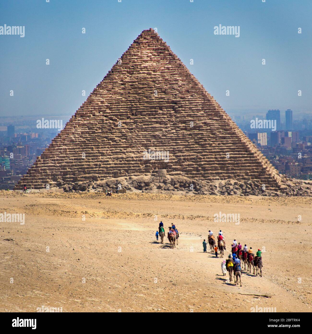 Touristen Reiten Kamele zu einer Pyramide in Gizeh, Ägypten Stockfoto
