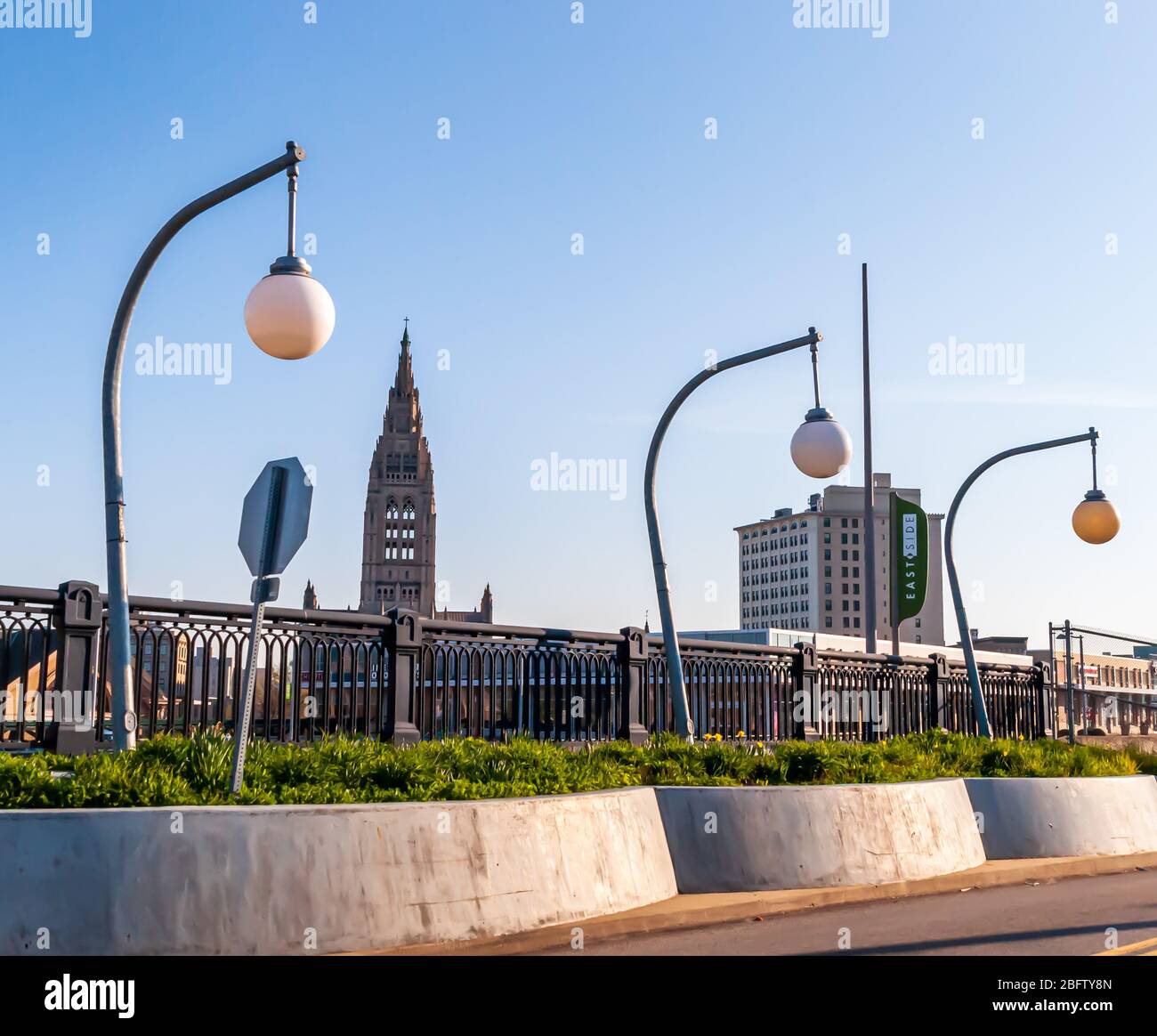 Dekorative Straßenlampen über einem Gehweg im Shadyside-Viertel mit einem Kirchturm und einem Mehrfamilienhaus im Hintergrund, PGH, PA, USA Stockfoto