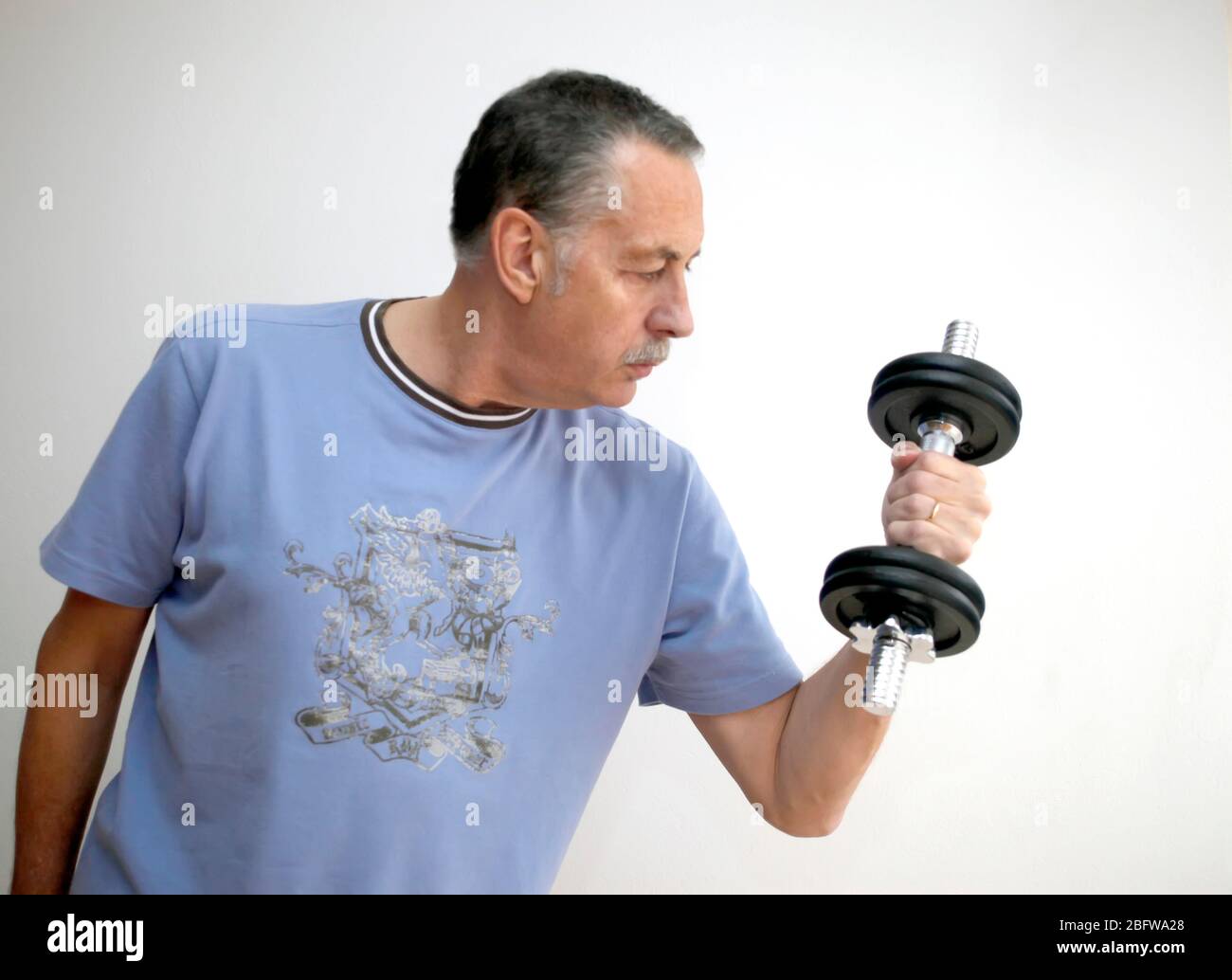 Reifer Mann mit Gewichten Stockfoto