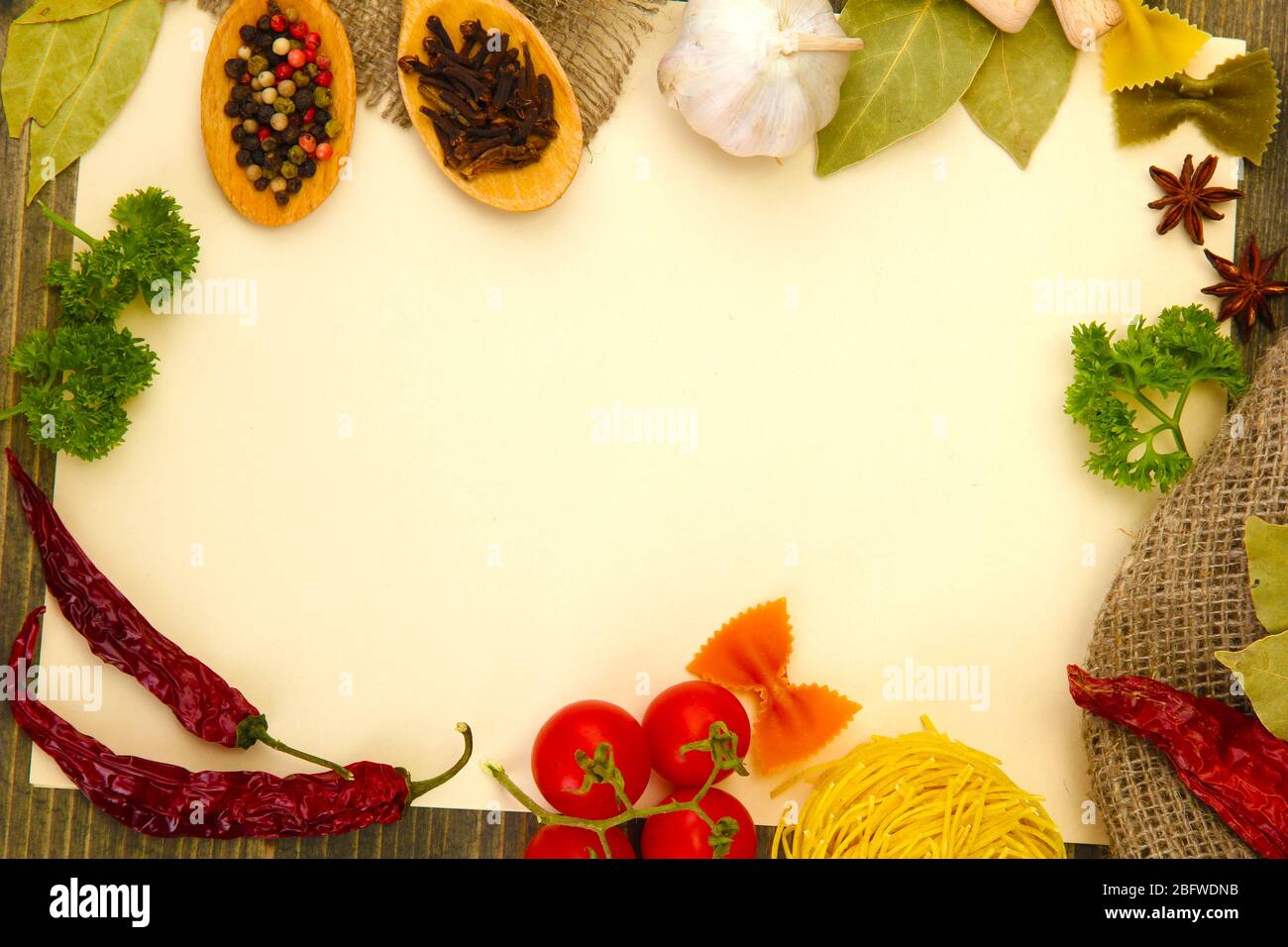Papier für Rezepte Gemüse und Gewürze auf Holztisch Stockfoto