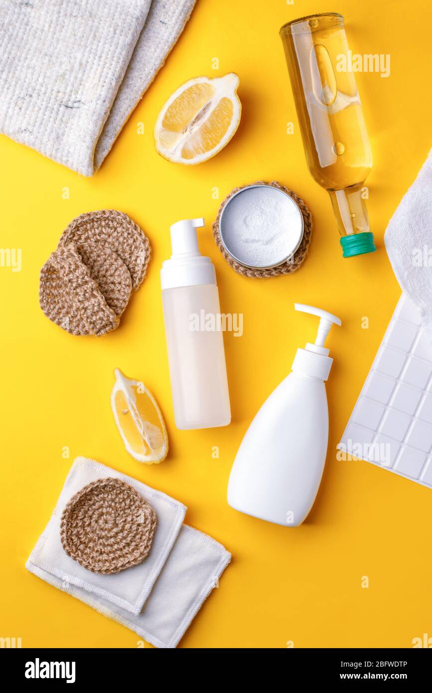 Set von umweltfreundlichen natürlichen Reinigungsmittel auf gelben Küchentisch: Soda, ätherische Öle, Zelluloseschwamm, Lumpen, Zitrone, Seife, Essig. Keine Verschwendung, Stockfoto