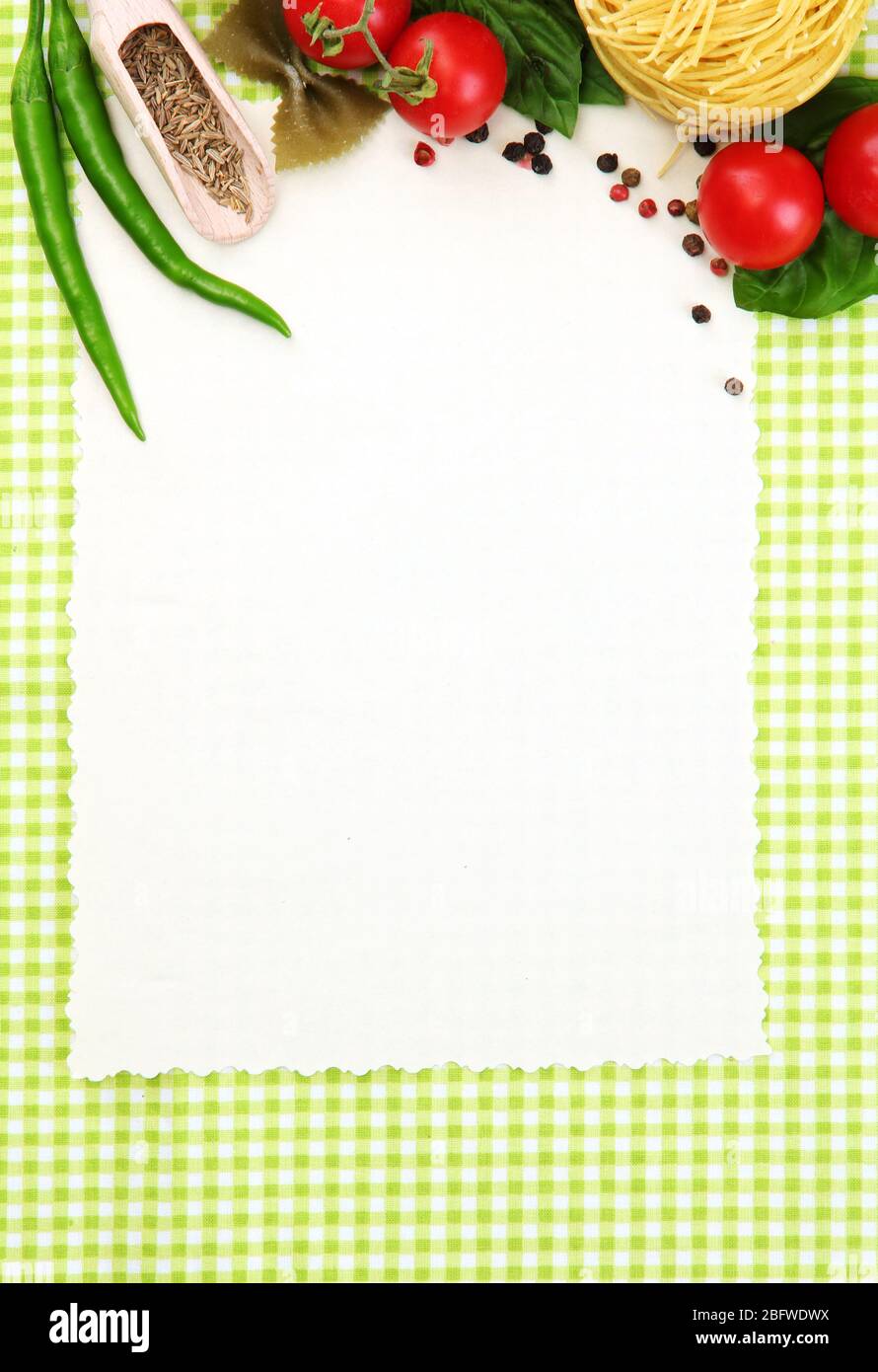 Papier für Rezepte, Gemüse und Gewürze auf grünem Hintergrund Stockfoto