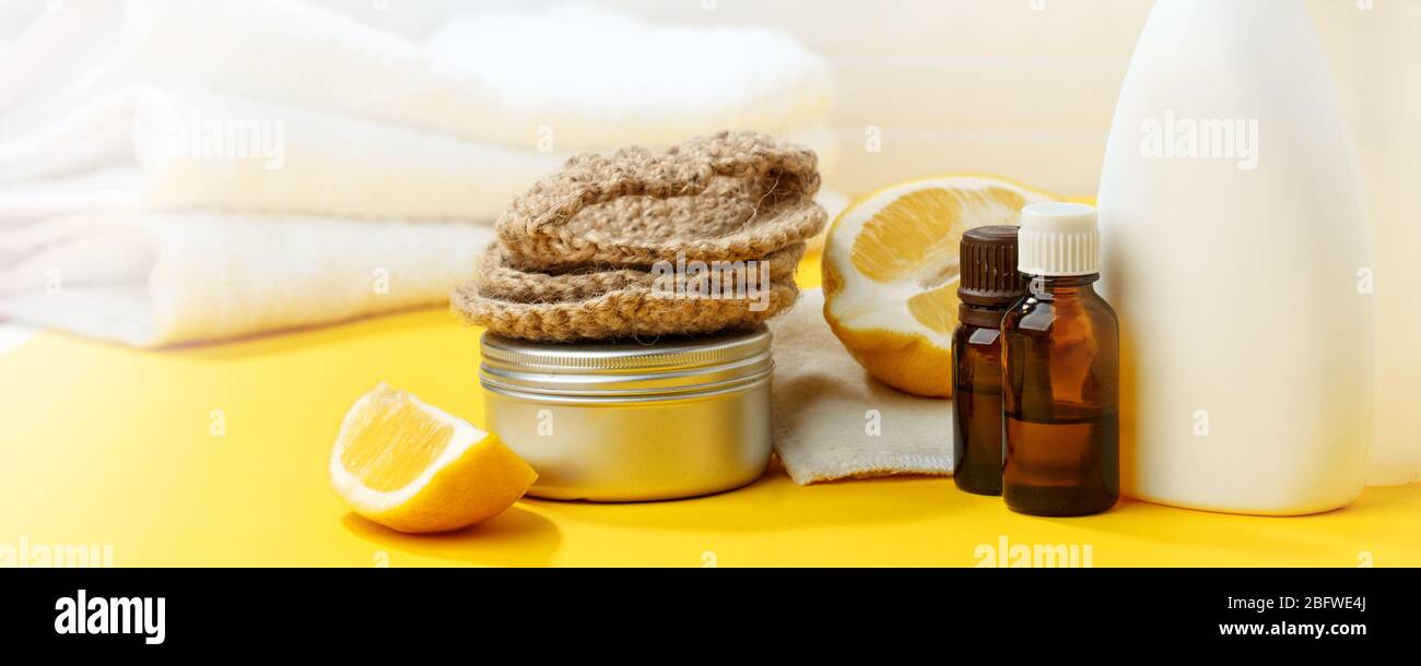 Set von umweltfreundlichen natürlichen Reinigungsmittel auf gelben Küchentisch: Soda, ätherische Öle, Zelluloseschwamm, Lumpen, Zitrone, Seife, Essig. Keine Verschwendung, Stockfoto