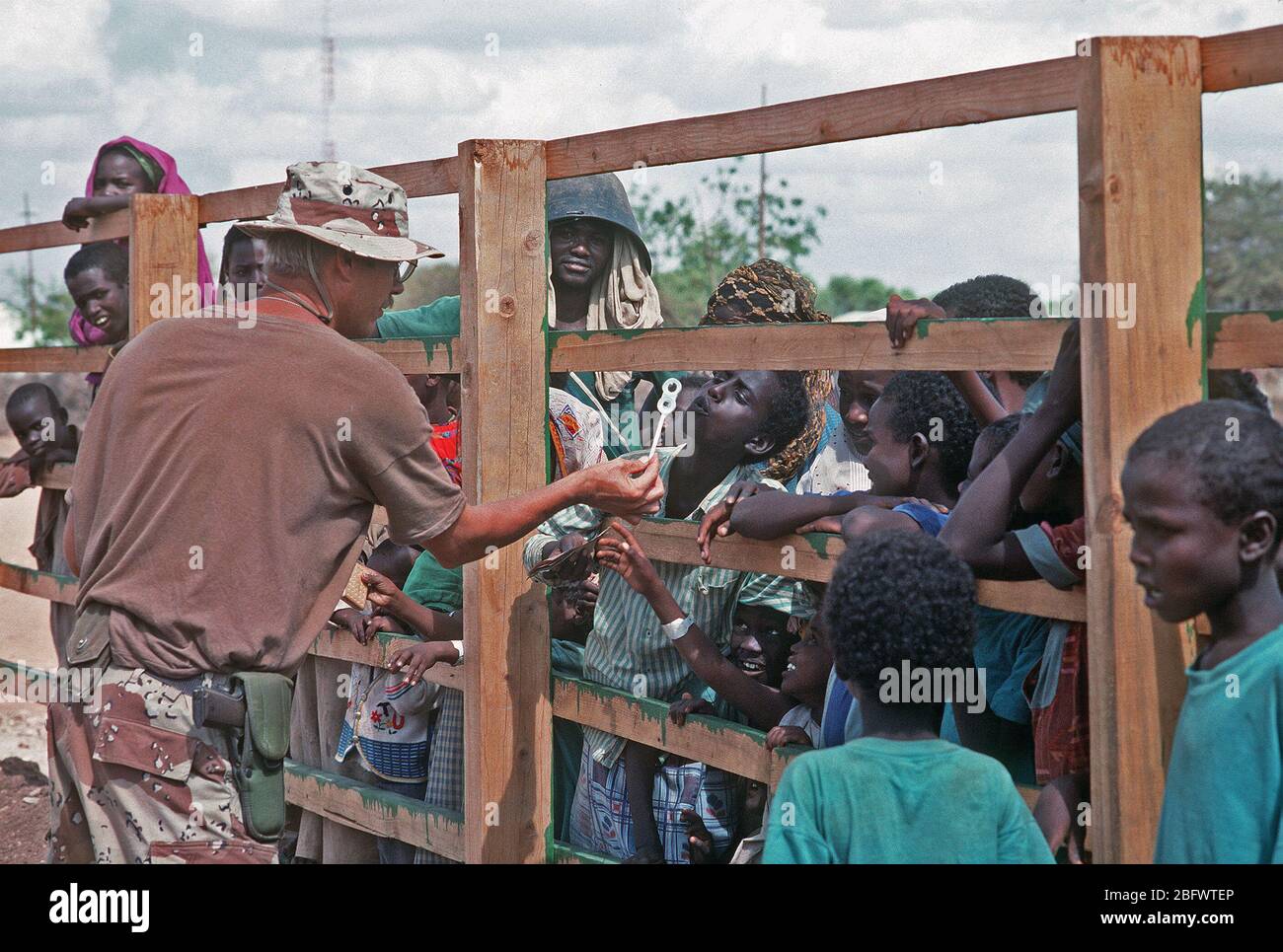 Chief's Fotograf Mate Robert Sasek unterhält eine Gruppe von somalischen Kinder beobachten Mitglieder des Schiffsbaus Bataillon 1 (NMCB-1) in einen Schulhof arbeiten. NMCB-1 arbeitet die Schule als Teil einer bürgerschaftlichen Aktion zu verbessern, während die multinationalen Entlastung Bemühung Operation Restore Hope. Stockfoto