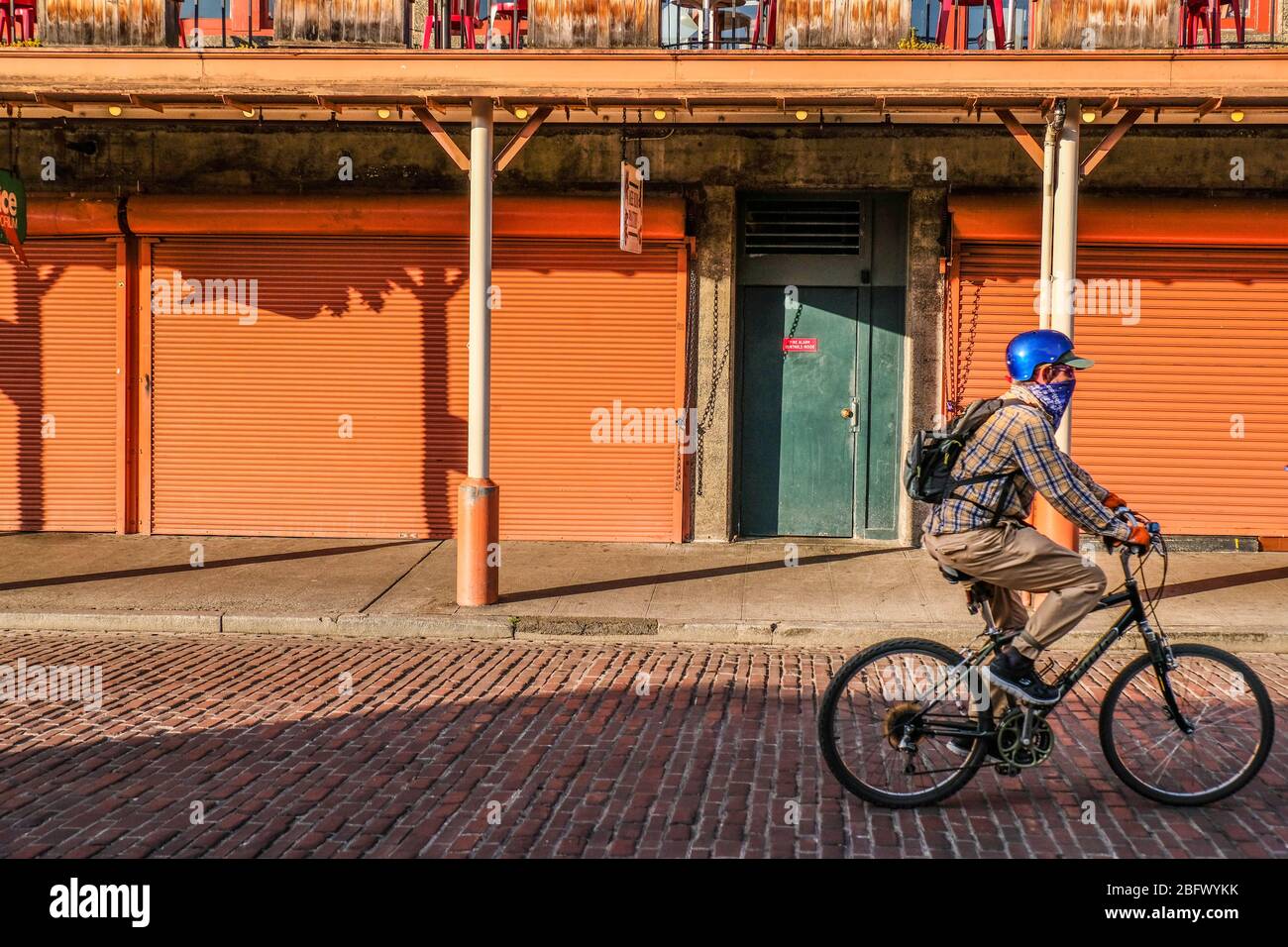 Ein Mann auf dem Fahrrad vor dem Laden in der leeren Straße in der Innenstadt von Seattle, wegen Coronavirus Aufenthalt zu Hause bestellen Stockfoto