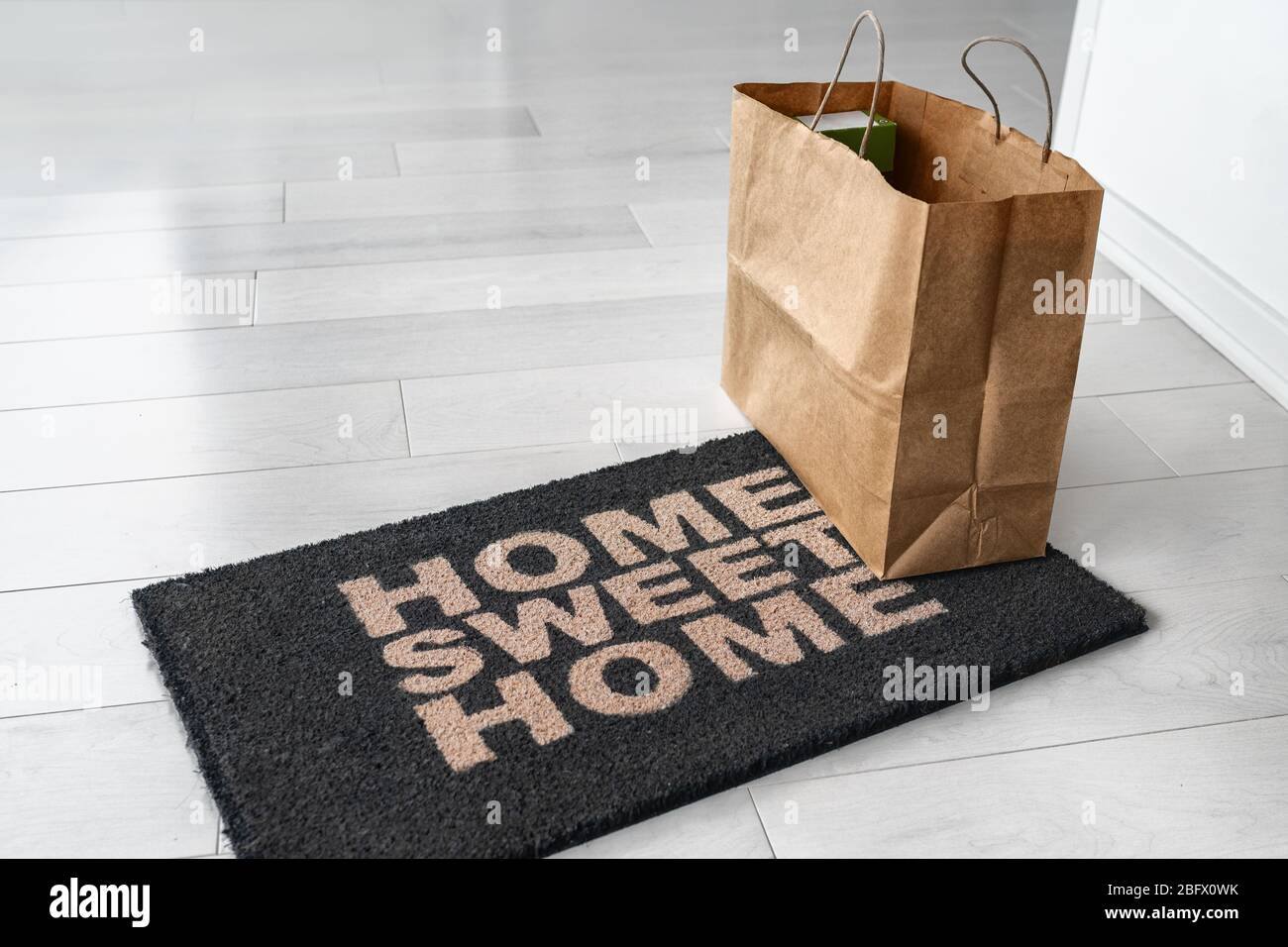 Hauszustellung von Lebensmitteln Lebensmitteltasche an der Tür Eingang Matte für Corona Virenschutz Sicherheit gelassen. Vorsichtsmaßnahmen gegen COVID-19, Papiersack ohne Kontakt geliefert. Stockfoto