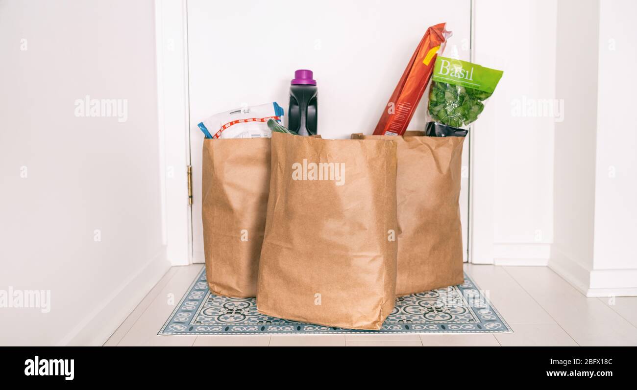 Lebensmittelgeschäft Online-Lieferung Empfang Lebensmitteltaschen zu Hause Eingangstür vor der Haustür Flur kontaktlose Empfang von Lebensmitteln Lieferungen während der Quarantäne COVID-19 Coronavirus. Stockfoto