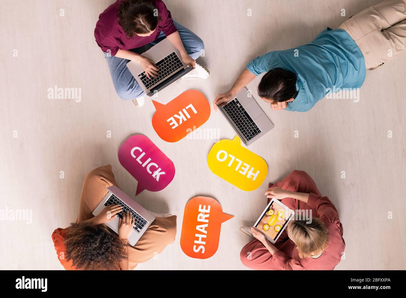 Über Ansicht von Internet-Nutzern mit modernen Geräten während der Interaktion online, bunt wie, Hallo, Teilen, Klicken Sie Tags auf dem Boden Stockfoto