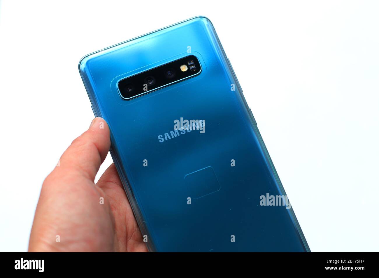 Hand halten Samsung Galaxy S10+ Smartphone isoliert vor weißem Hintergrund Stockfoto