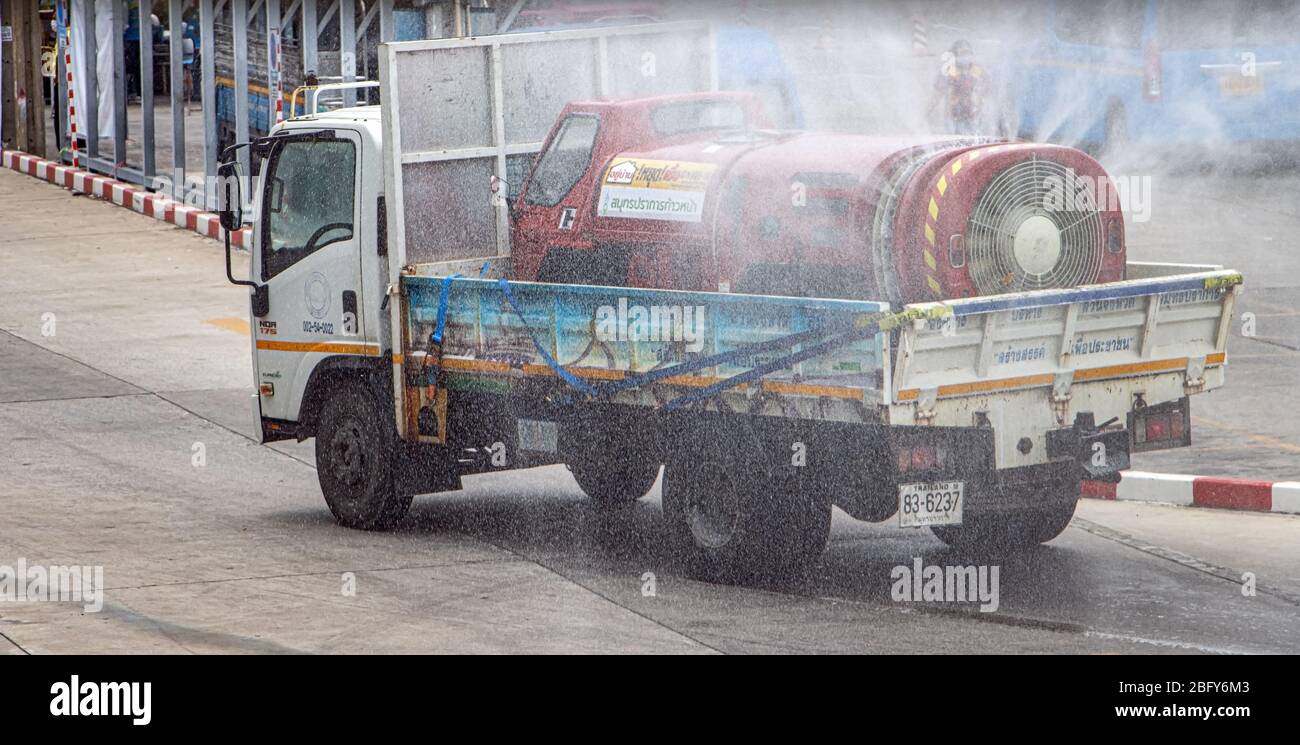 SAMUT PRAKAN, THAILAND, APR 17 2020, EIN LKW mit kleinerem Spezialauto mit Zisterne desinfiziert eine Straße. Spray aus Tank Auto reinigt Stadt. Stockfoto