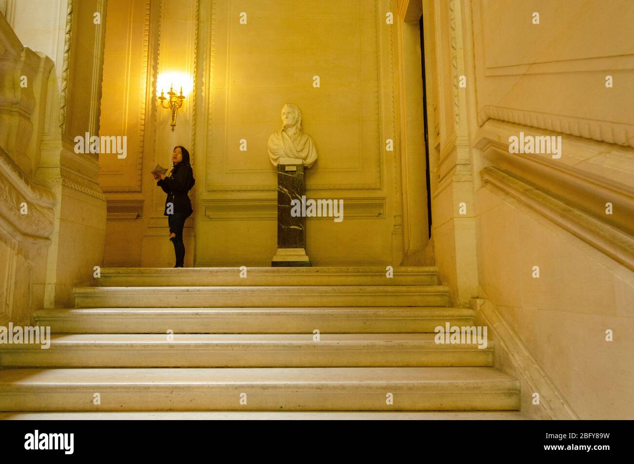 Eine offene Aufnahme einer asiatischen Touristenfrau, die den Louvre in Paris, Frankreich, erkundet Stockfoto