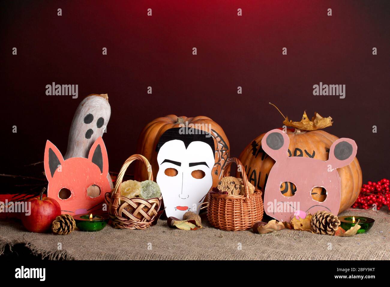 Trick or Treat halloween Masken und Eimer gefüllt mit Cookies auf farbigen Hintergrund Stockfoto