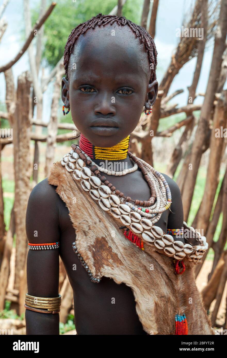 Omo Valley - Äthiopien - Afrika, 2. Januar 2013: Junges unidentifiziertes Mädchen des Hamer Stammes stehend mit traditionallen Ornamenten in Omo Val Stockfoto