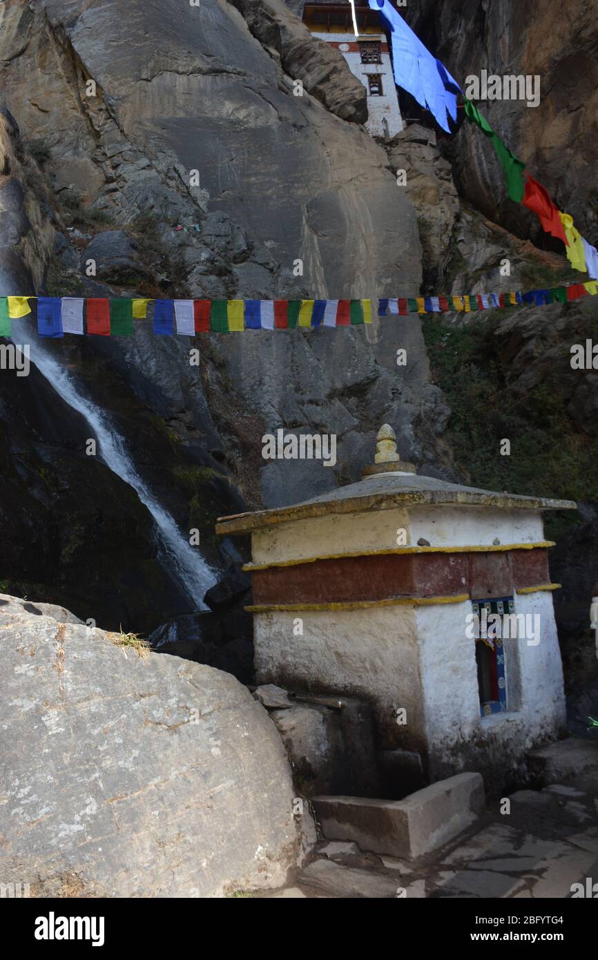 Gebetsrad und Einsiedlerhaus auf dem Weg zum Tiger's Nest Kloster (alias der Taktsang Trail nach Paro Taktsang), Bhutans beliebteste Touristenattraktion. Stockfoto