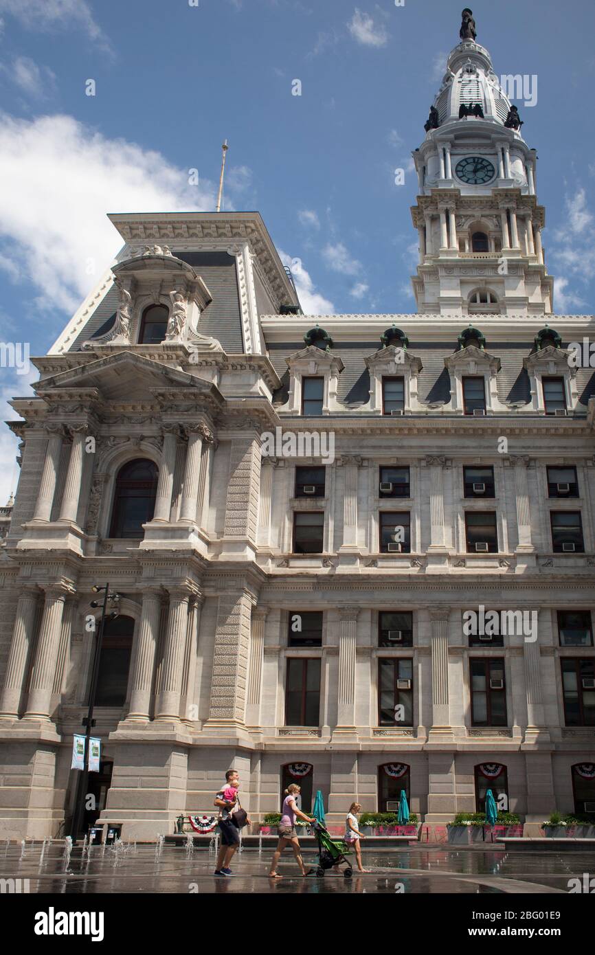 Vertikale Aufnahme einer Familie, die am Rathaus in Philadelphia, Pennsylvania vorbeigeht Stockfoto